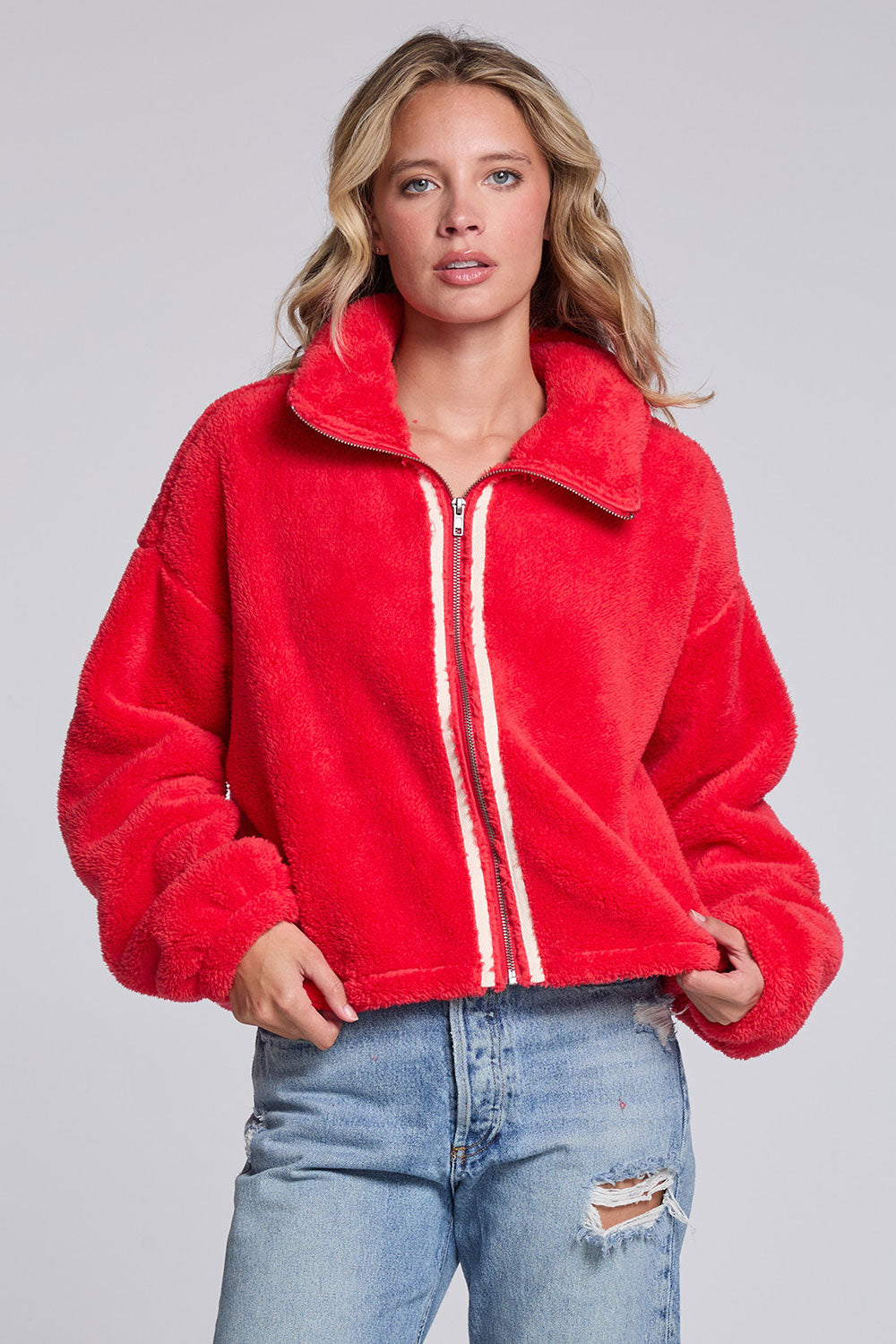 Model wearing Chaser's Cherry Zip-Up in Cherry Bomb red plush zip-up jacket with high collar, front view