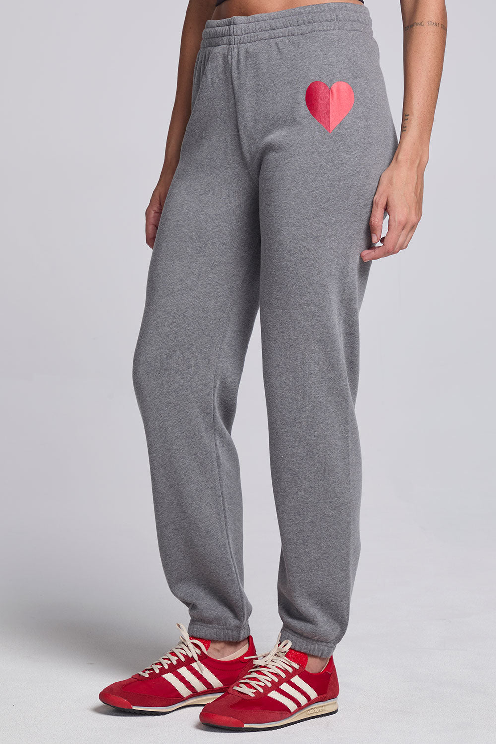 Model wearing Chaser's Dual Tone Heart Jogger in Streaky with a single red heart, angled view