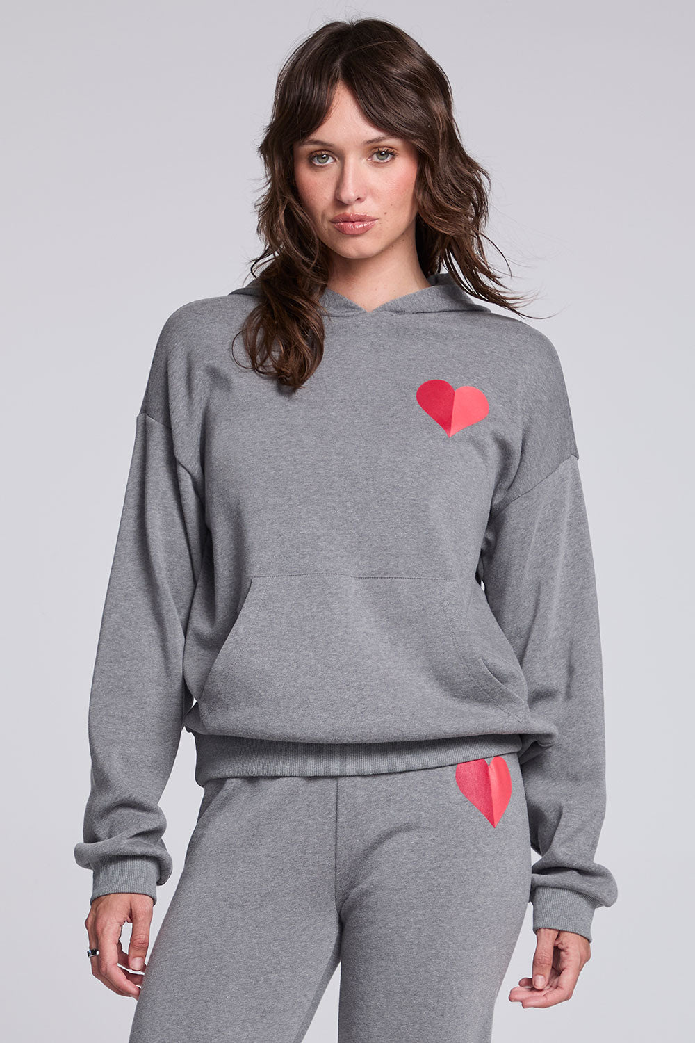 Model wearing Chaser's Dual Tone Heart Hoodie in Streaky with a single red heart, front view