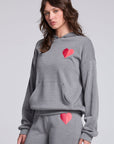 Model wearing Chaser's Dual Tone Heart Hoodie in Streaky with a single red heart, angled view