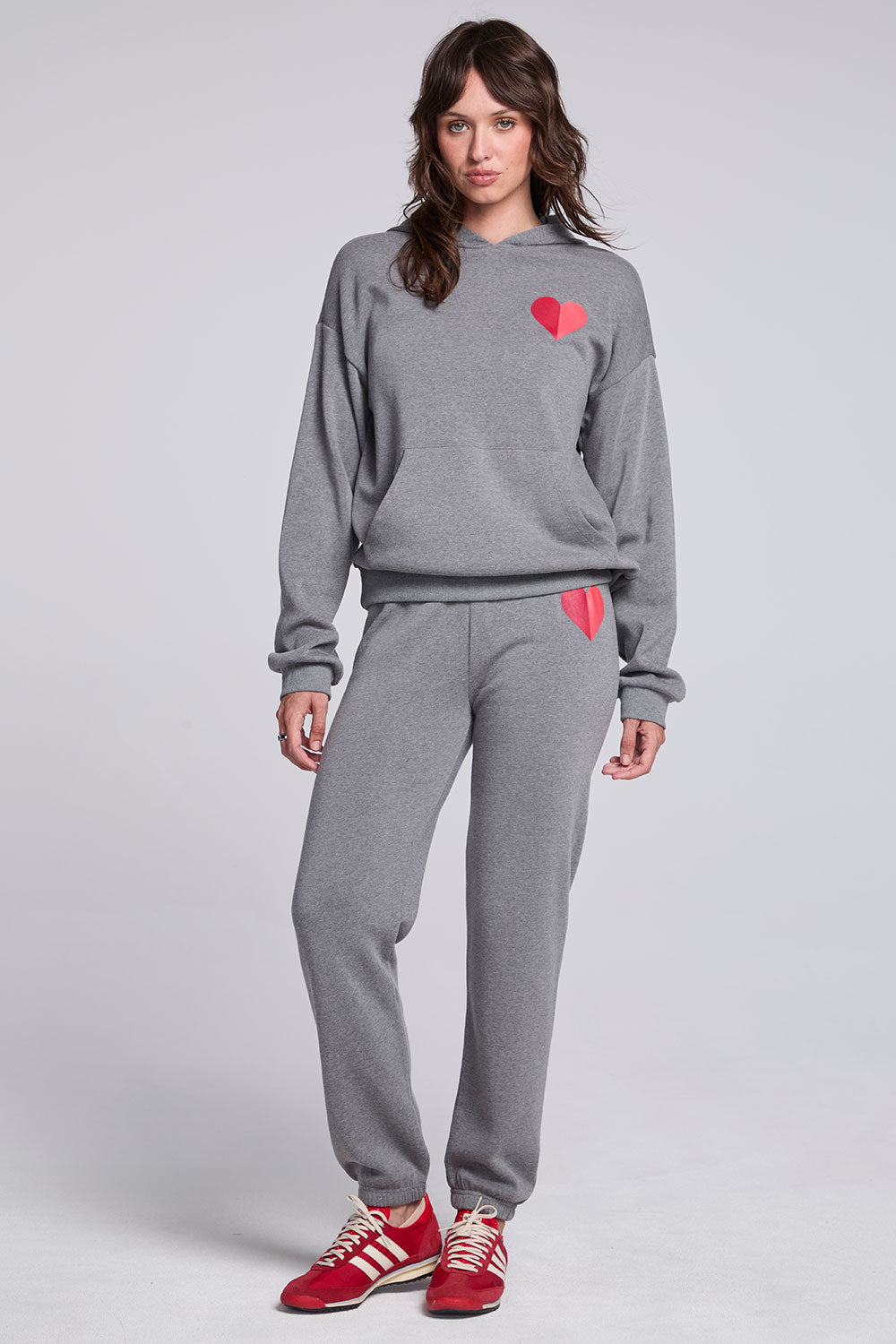 Model wearing Chaser's Dual Tone Heart Hoodie and matching Dual Tone Heart Jogger in Streaky Grey with red heart details, full-body view