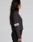 Side view of a woman wearing the Chaser 11 Long Sleeve and black jeans on a neutral background
