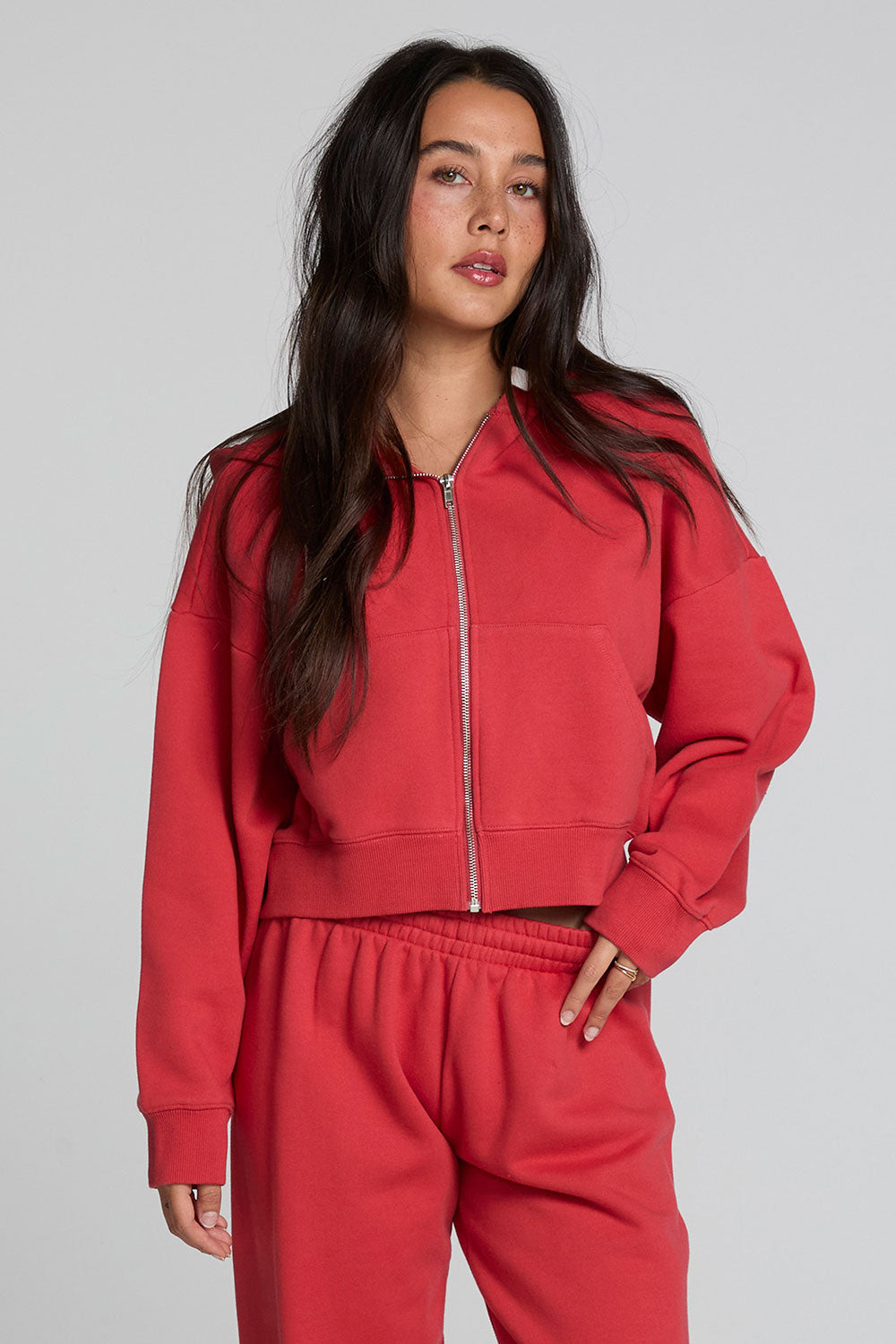 Front view of a woman wearing the Chaser  Abilene Dry Red Zip Upon a neutral background