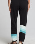 Back view of a woman wearing the Chaser Ada Black Jogger on a neutral background with arms at sides and sneakers