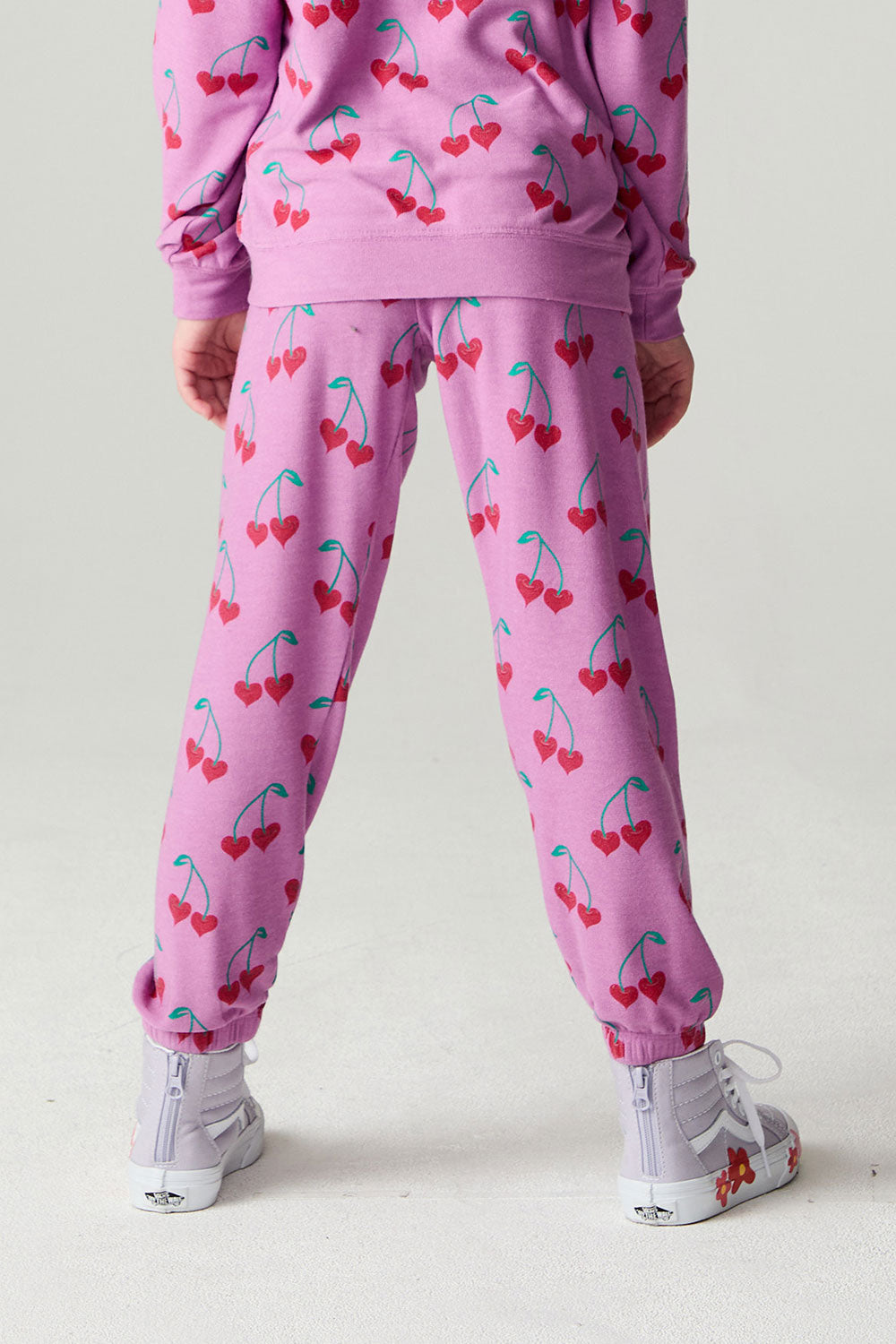 Back view of a girl wearing the Chaser Allover Sweethearts Girls Jogger on a neutral background