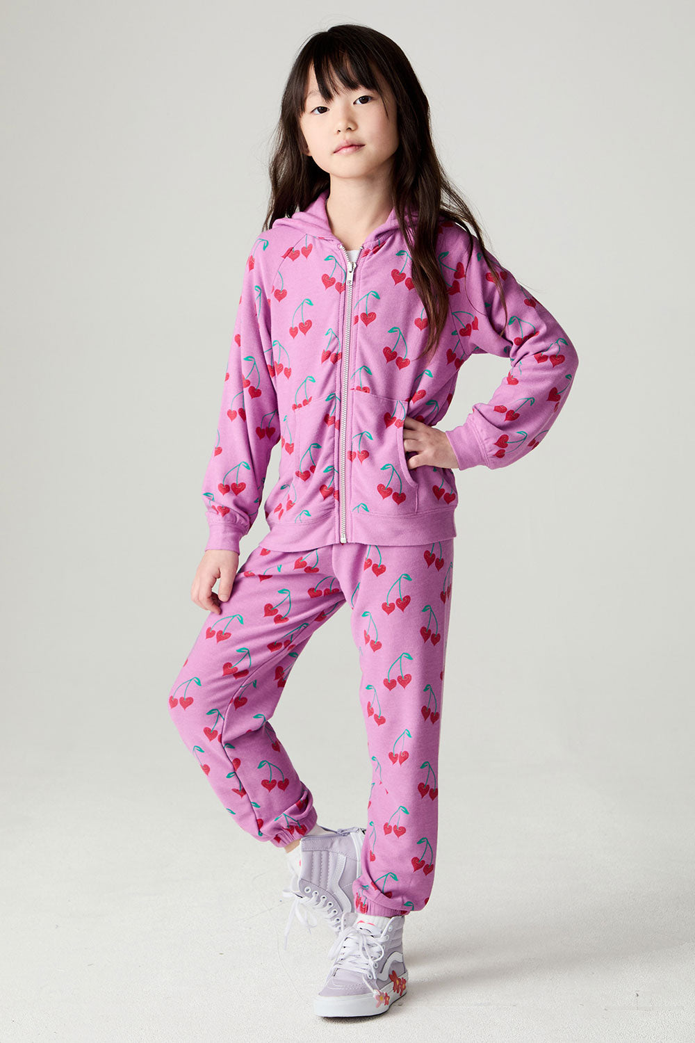 Full body front view of a girl wearing the Chaser Allover Sweethearts Girls Jogger on a neutral background with matching top