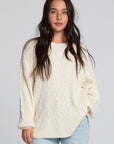 Front view of a woman wearing the Chaser Antique White Harpur Pullover on a neutral background with lightwash jeans