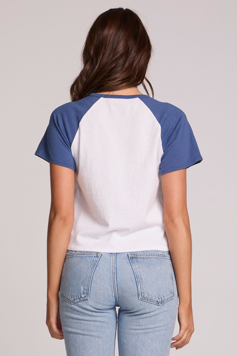 Back view of a woman wearing the Chaser Athletics Club Tee on a neutral background with jeans