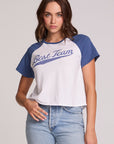 Front view of a woman wearing the Chaser Athletics Club Tee on a neutral background with blue jeans and hand in pocket