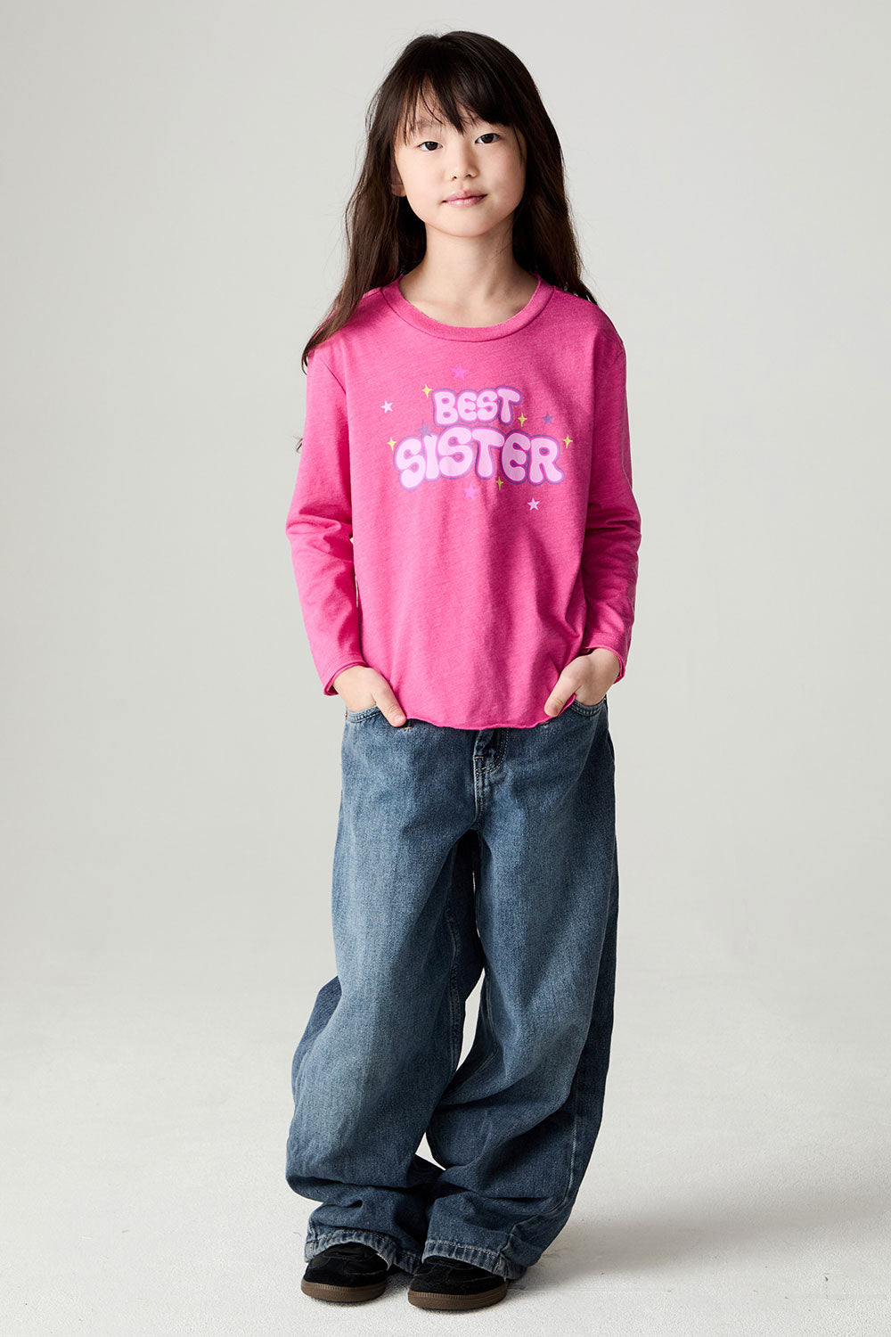 A full body front view of a girl wearing the Chaser Best Sister Girls Tee on a neutral background