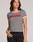 Front view of a woman wearing the Chaser Bisous Tee on a neutral background with black pants with hand on hip