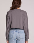 Back view of a woman wearing the Chaser Blondie Live Cropped Sweatshirt on a neutral background with hands at sides