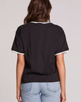 Back view of a woman wearing the Chaser Brooklyn Varsity Graphic Tee on a neutral background with hands at sides
