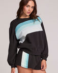 Front view of a woman wearing the Chaser  Cashbah Black Pullover on a neutral background with matching shorts