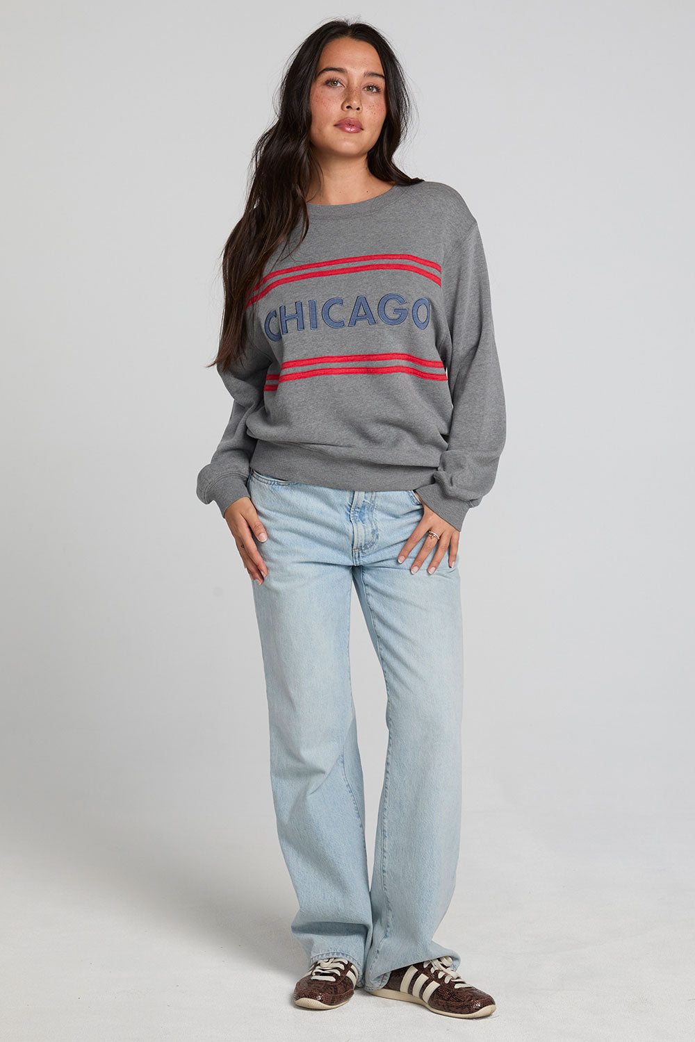 A full body front view of a woman wearing the Chaser Chicago Sweatshirt on a neutral background