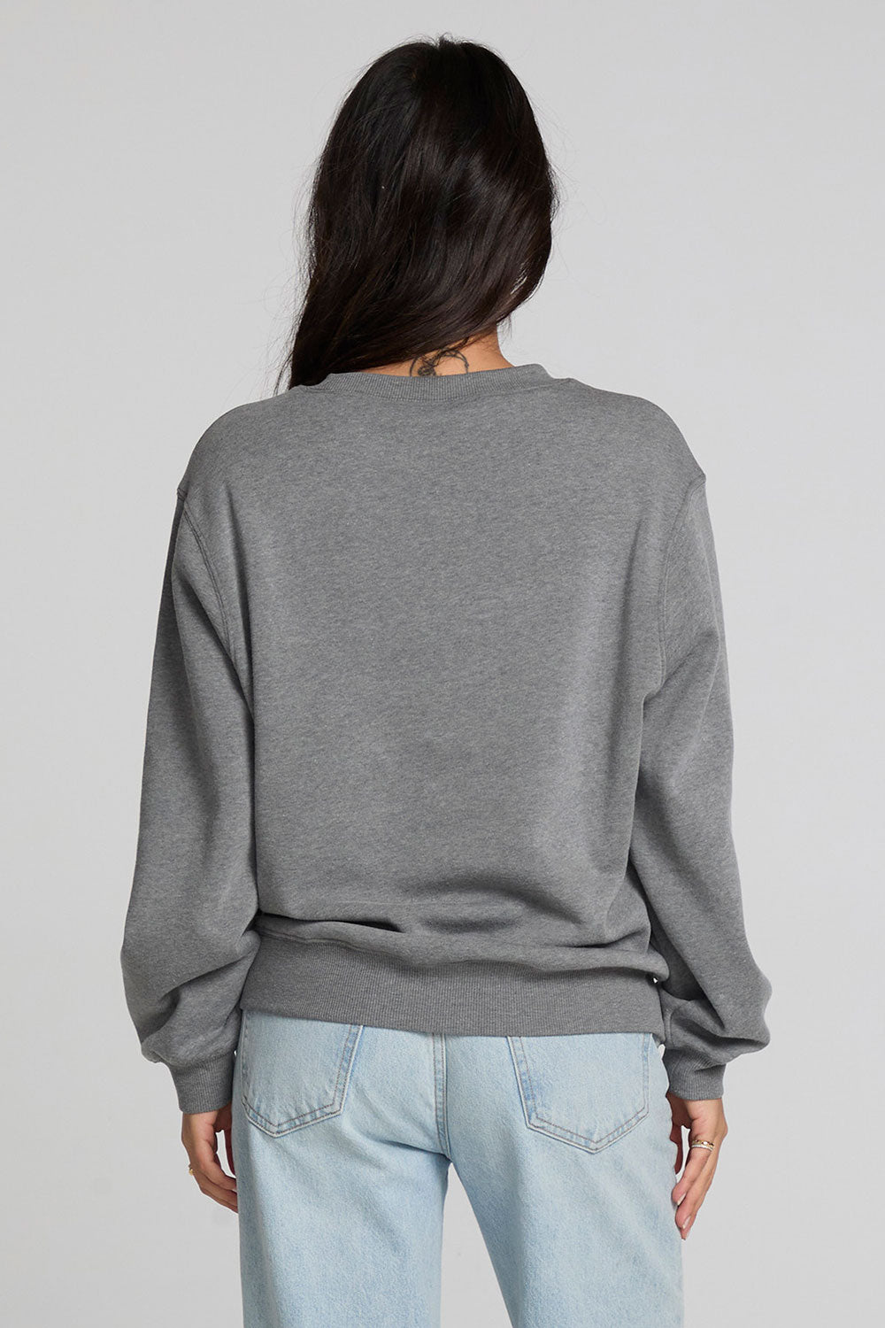 Back view of a woman wearing the Chaser Chicago Sweatshirt on a neutral background with hair over shoulder