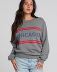 Front view of a woman wearing the Chaser Chicago Sweatshirt and jeans on a neutral background