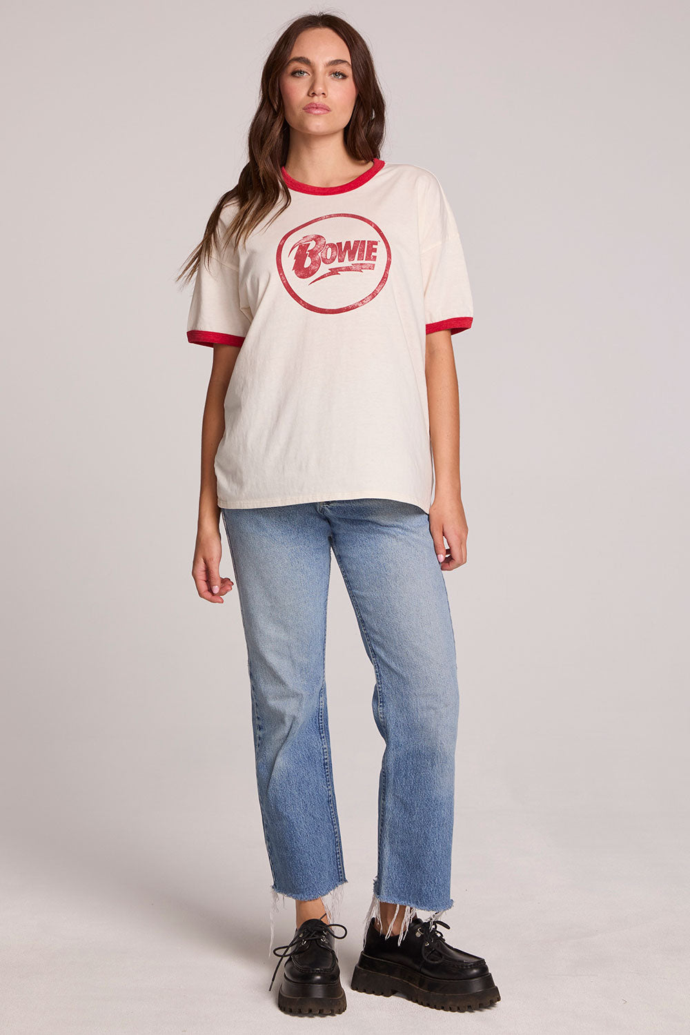 A full body front view of a woman wearing the Chaser David Bowie Bowie Bolt Tee on a neutral background