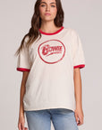 Front view of a woman wearing the Chaser David Bowie Bowie Bolt Tee on a neutral background with bluejeans and hands lowered