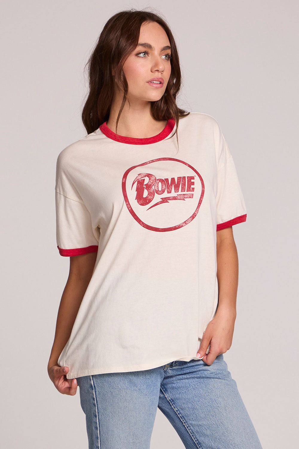 Front view of a woman wearing the Chaser David Bowie Bowie Bolt Tee on a neutral background with bluejeans