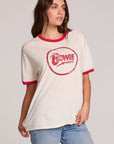 Front view of a woman wearing the Chaser David Bowie Bowie Bolt Tee on a neutral background with bluejeans