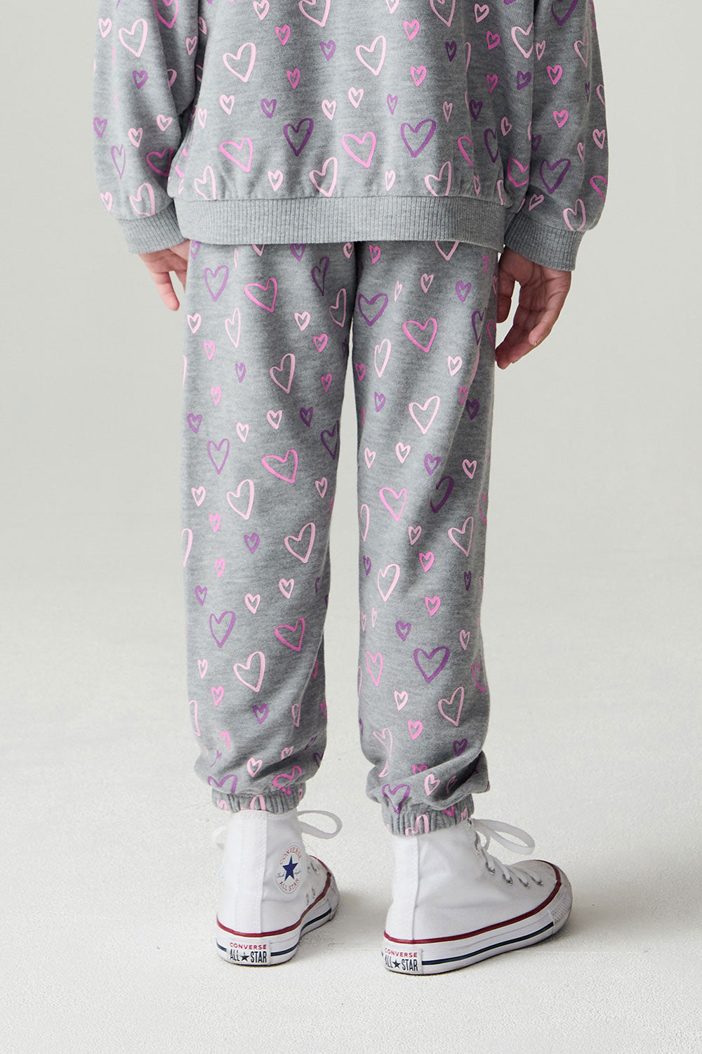 Back view of a girl wearing the Chaser Ditsy Hearts Girls Jogger on a neutral background