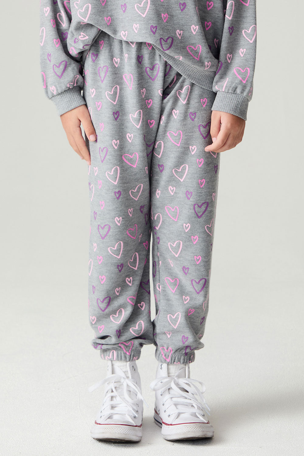 Front view of a girl wearing the Chaser Ditsy Hearts Girls Jogger on a neutral background with matching shirt