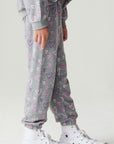 Side view of a girl wearing the Chaser Ditsy Hearts Girls Jogger on a neutral background with shirt