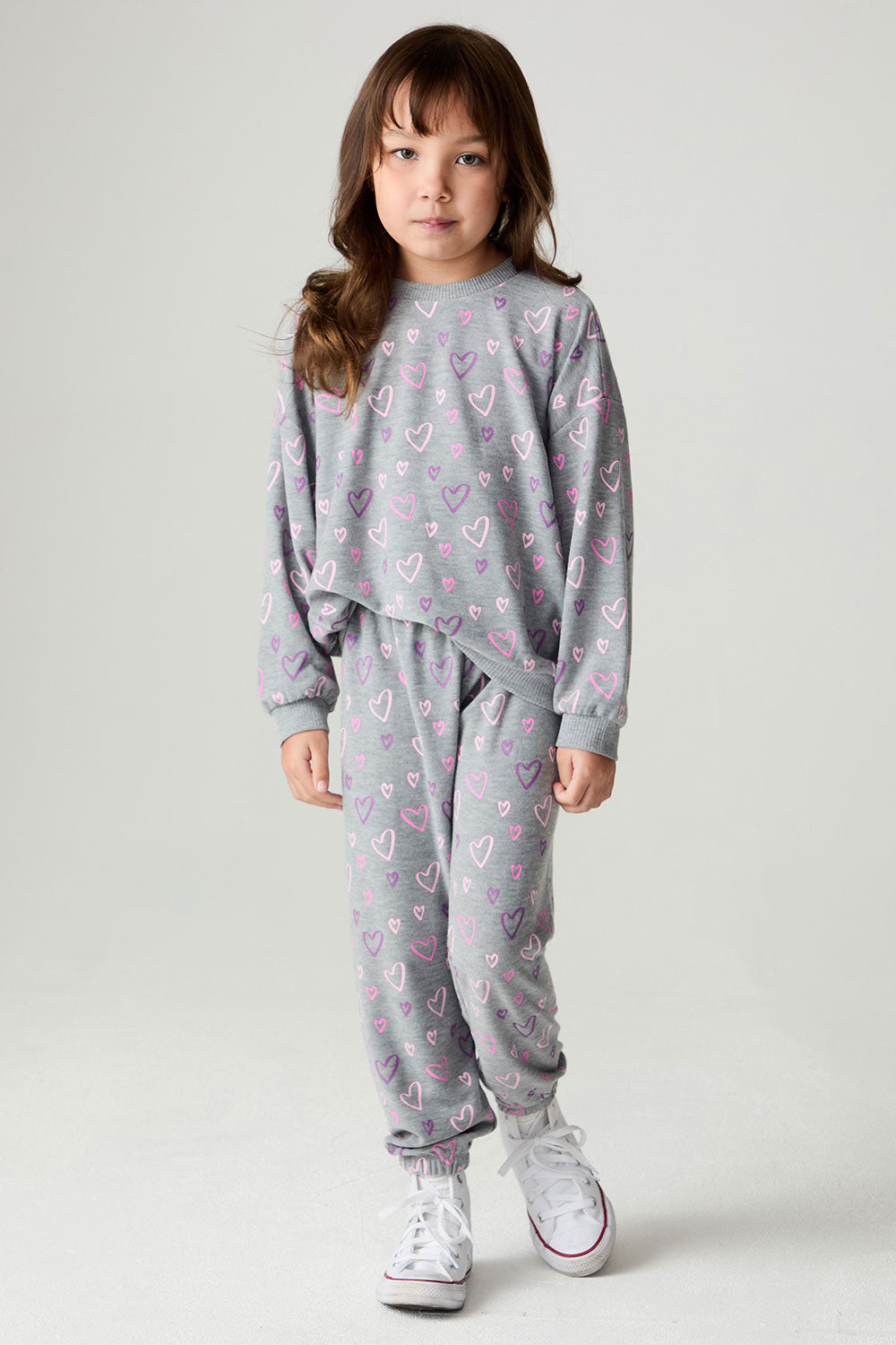 Front view of a girl wearing the Chaser Ditsy Hearts Girls Jogger matching set on a neutral background