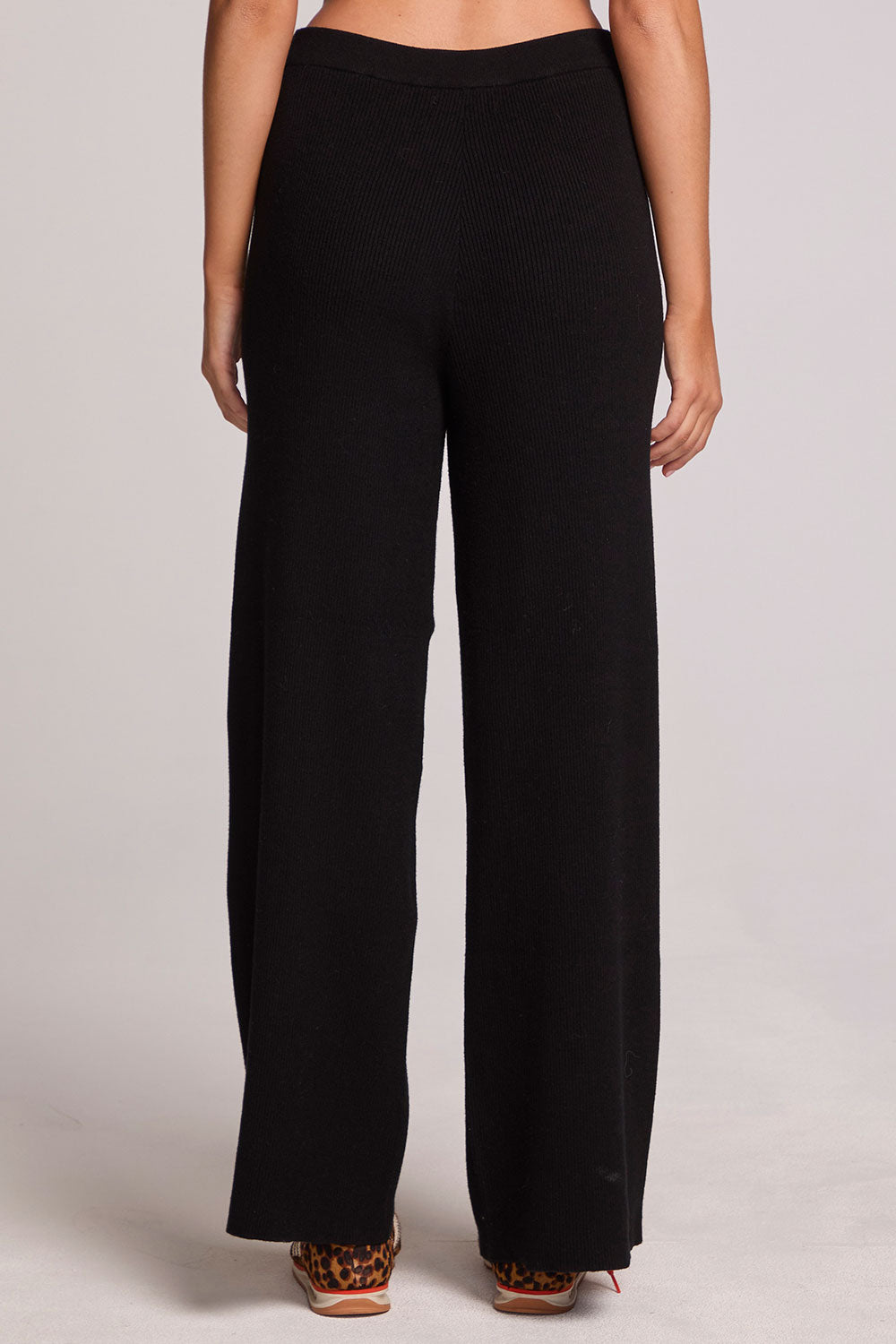 Back view of a woman wearing the Chaser Eliza Black Pants on a neutral background