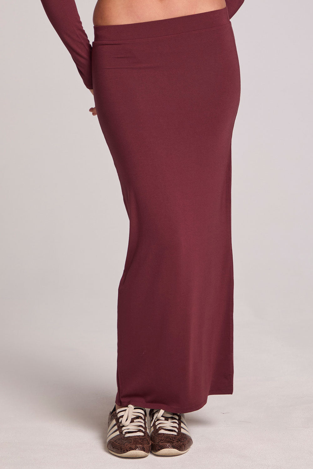 Front view of a woman wearing the Chaser Eloyse Brick Red Skirt on a neutral background with matching red top