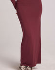 Front view of a woman wearing the Chaser Eloyse Brick Red Skirt on a neutral background with matching red top