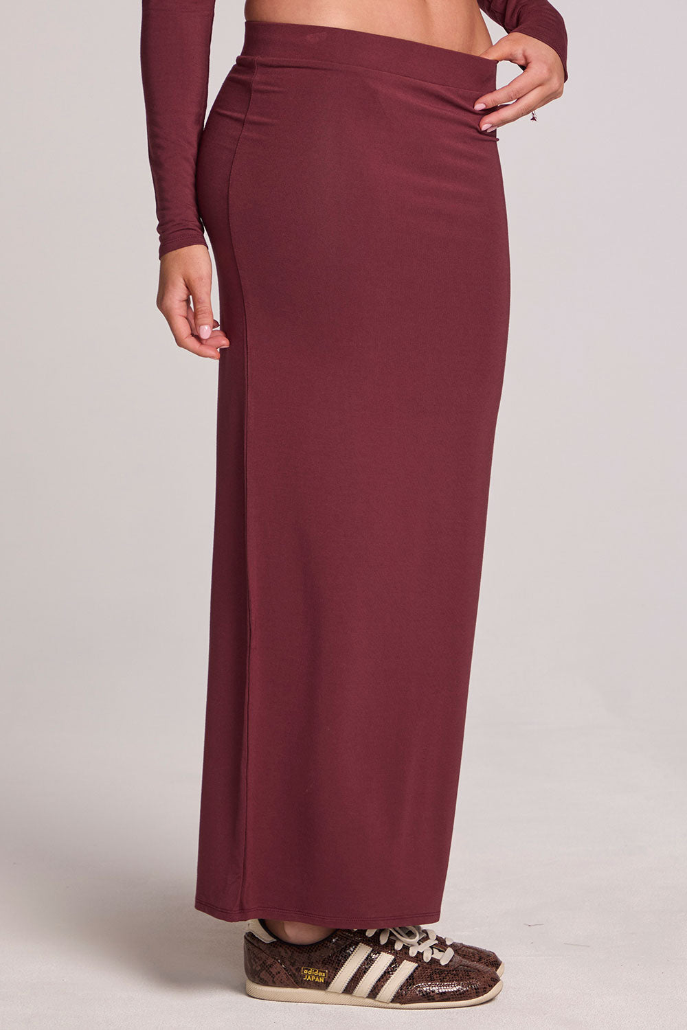 Front view of a girl wearing the Chaser Eloyse Brick Red Skirt on a neutral background with matching top