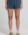 Front view of a woman wearing the Chaser  Eyla Dark Denim Shorts on a neutral background with sneakers