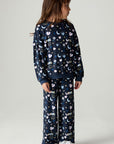 Full body front view of a girl wearing the Chaser Free Draw Girls Tee and pants on a neutral background looking to one side