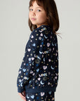 Side view of a girl wearing the Chaser Free Draw Girls Tee and matching pants on a neutral background