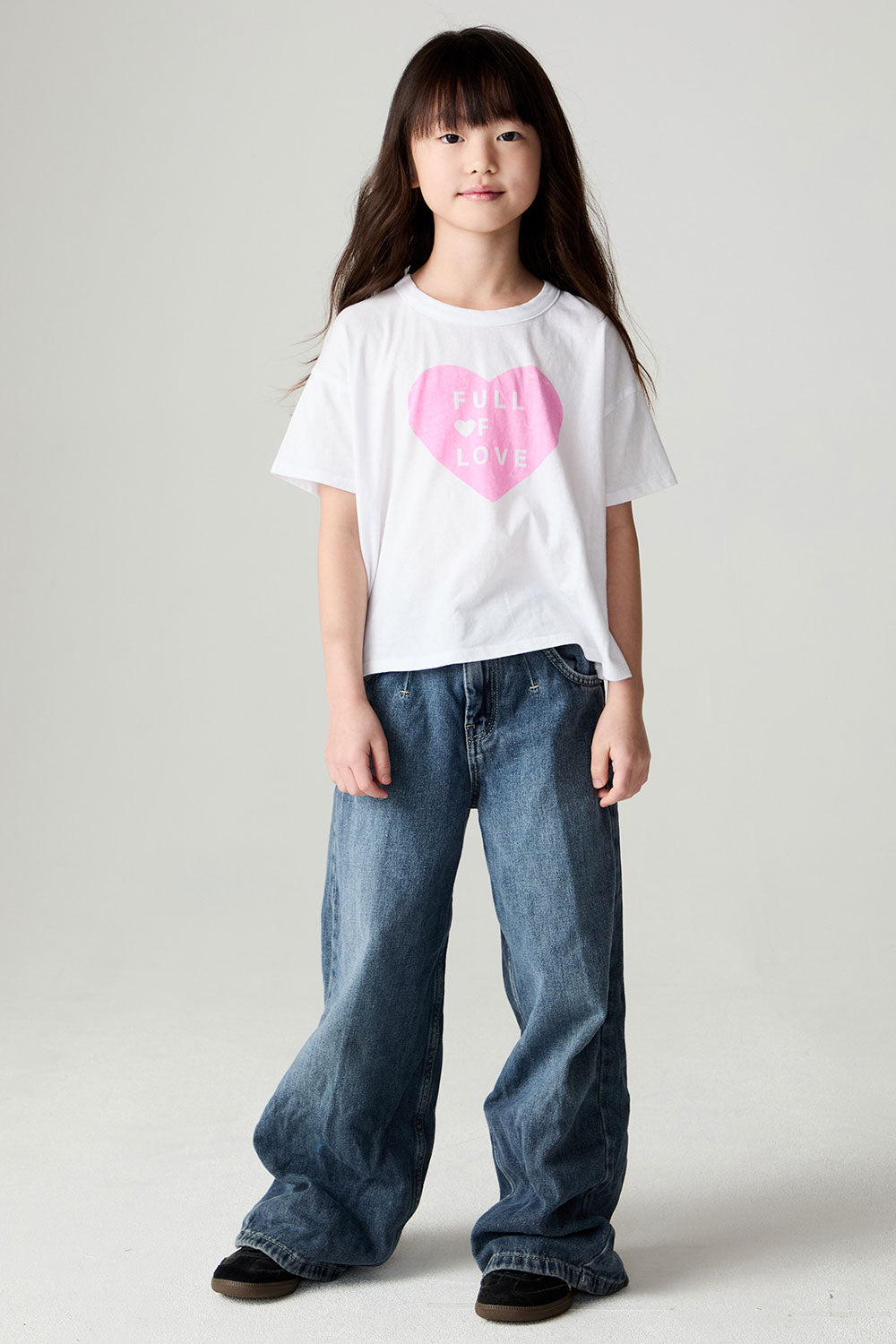 A full body front view of a girl wearing the Chaser Full Of Love Girls Tee on a neutral background