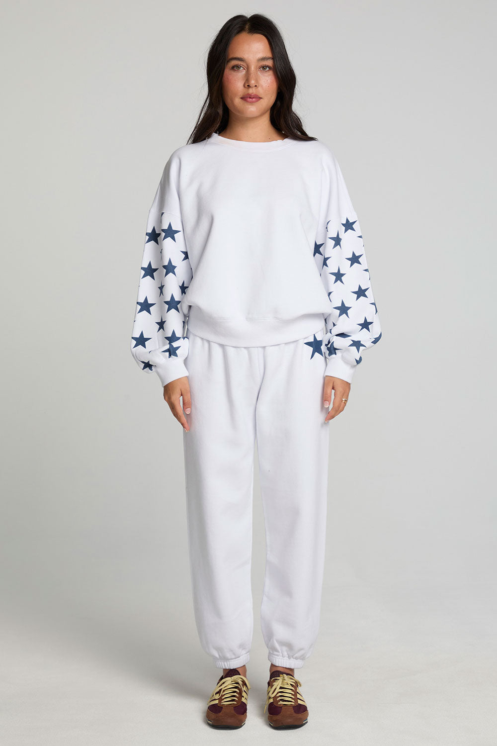 Full body front view of a woman wearing the Chaser High Spirits Long Sleeve on a neutral background with matching lounge pants