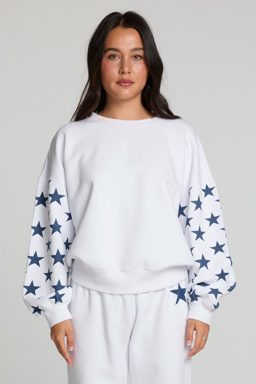 Front view of a woman wearing the Chaser   High Spirits Long Sleeve on a neutral background with matching pants