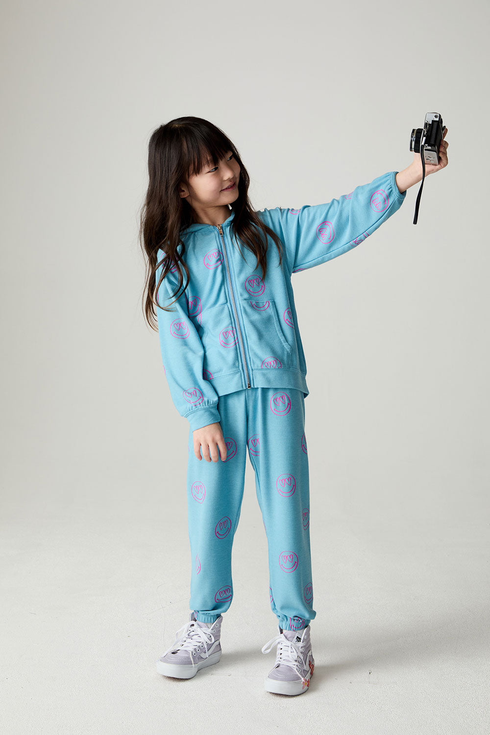 Full body front view of a girl wearing the Chaser I C Luv Girls Jogger on a neutral background holding camera