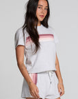 Side view of a woman wearing the Chaser  Isla Light Heather Grey Tee and shorts on a neutral background