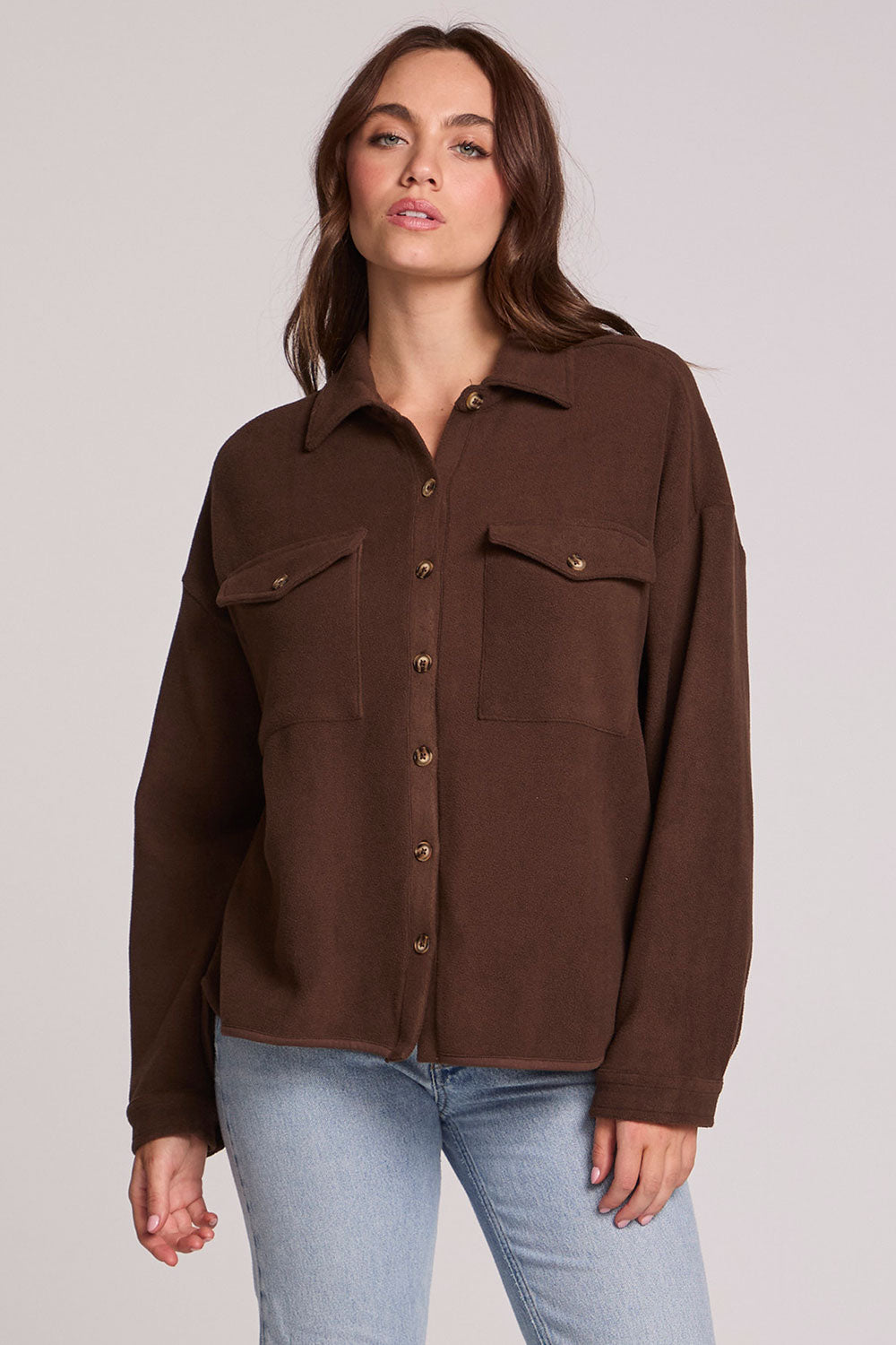 Front view of a woman wearing the Chaser Jaxxon Wood Brown Shacket on a neutral background
