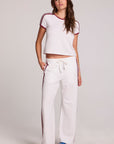 Full body front view of a woman wearing the Chaser Jessee Cloud White Trackpants set on a neutral background