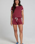 Full body front view of a woman wearing the Chaser  Jezz Burnt Red Shorts on a neutral background with arms lowered at sides