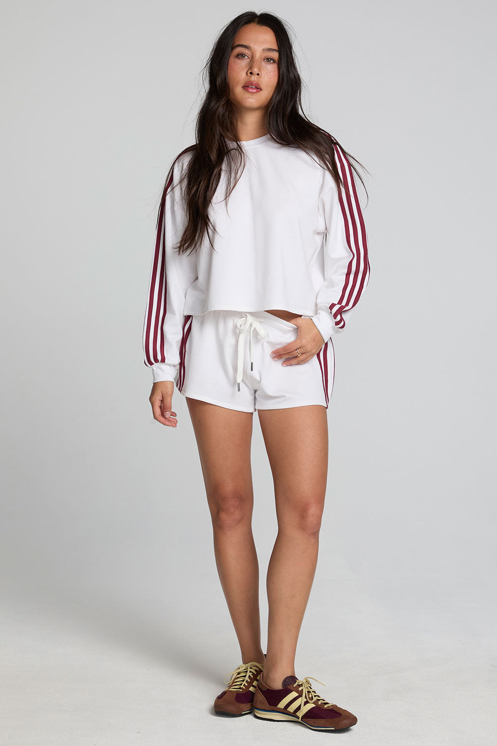Full body front view of a woman wearing the Chaser Jezz Cloud White Shorts on a neutral background with matching white top