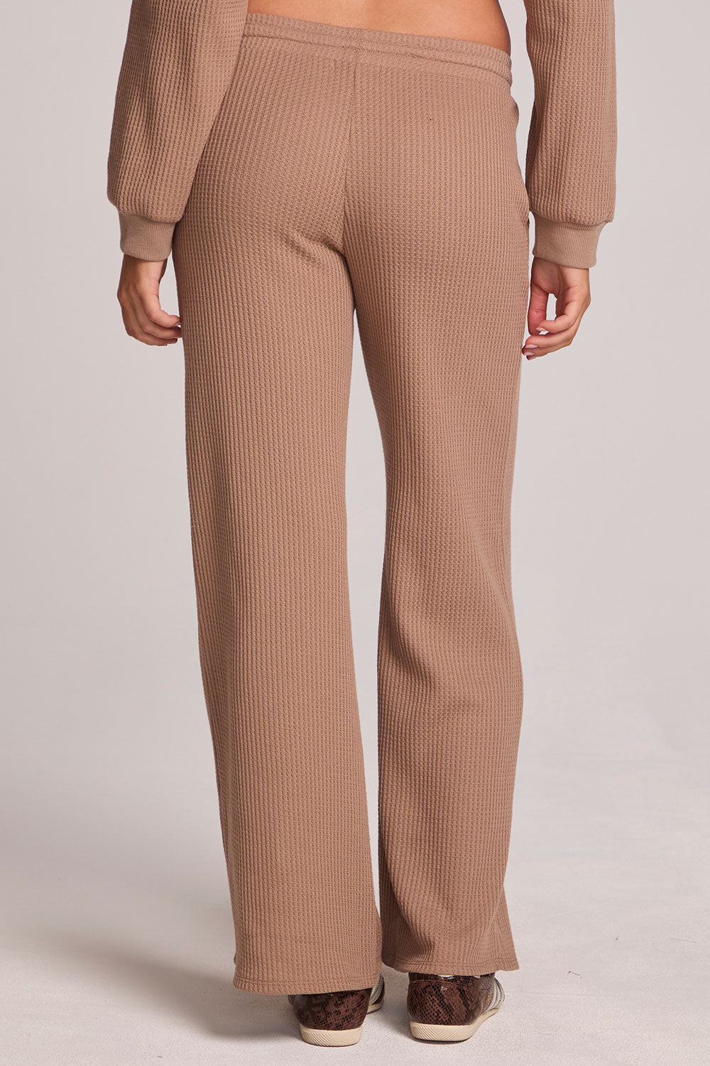 Back view of a woman wearing the Chaser Jorgia Camel Pants on a neutral background