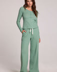 Full body front view of a woman wearing the Chaser  Jorgia Verdelle Pants on a neutral background with matching shirt