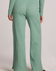 Back view of a woman wearing the Chaser  Jorgia Verdelle Pants on a neutral background