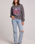 A full body front view of a woman wearing the Chaser Journey 1983 Tour Sweatshirt on a neutral background