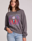 Side view of a woman wearing the Chaser Journey 1983 Tour Sweatshirt on a neutral background with bluejeans and hand on hip